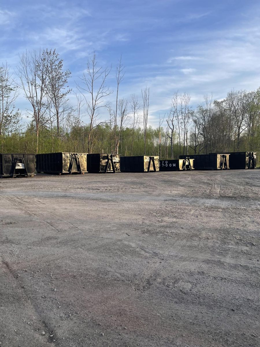 Row of Liberty Sanitation roll-off dumpsters lined up and ready for delivery
