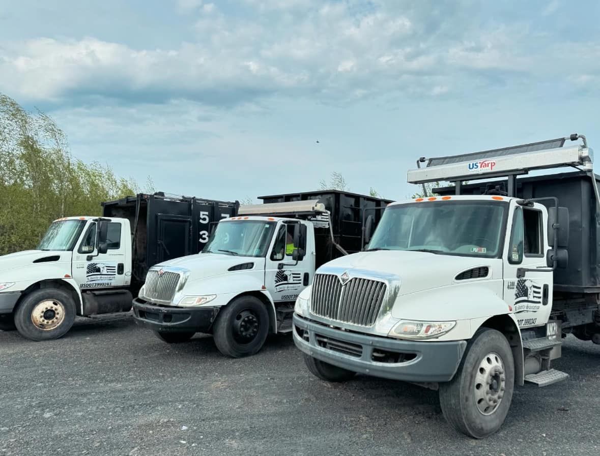 Three Liberty Sanitation trucks parked side by side